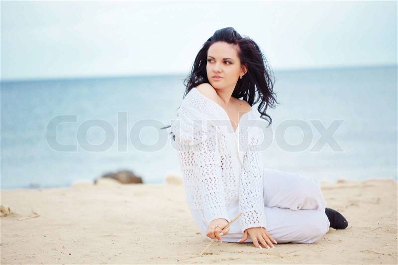 Young girl resting at beach near the sea, stock photo