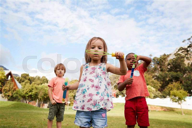 Children At Montessori School Playing With Bubbles During Break, stock photo