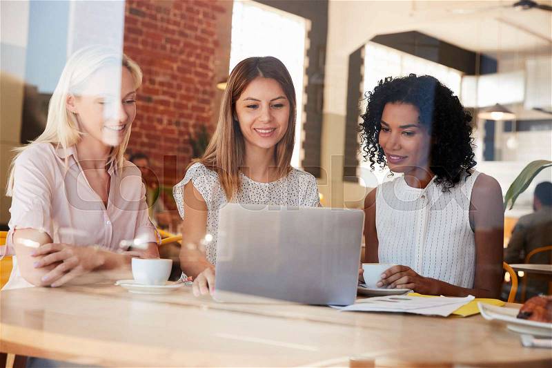 Three Businesswomen Meet In Coffee Shop Shot Through Window, stock photo