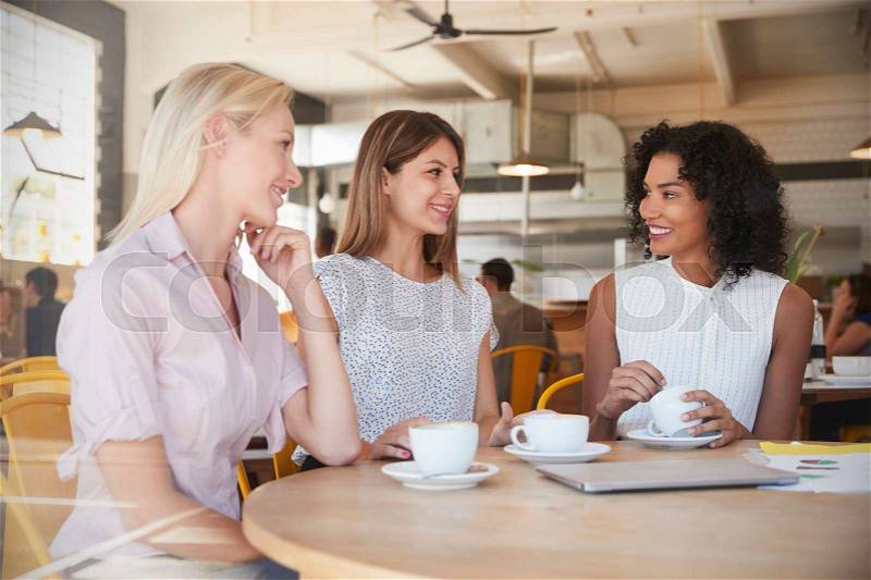 Three Businesswomen Meet In Coffee Shop Shot Through Window, stock photo