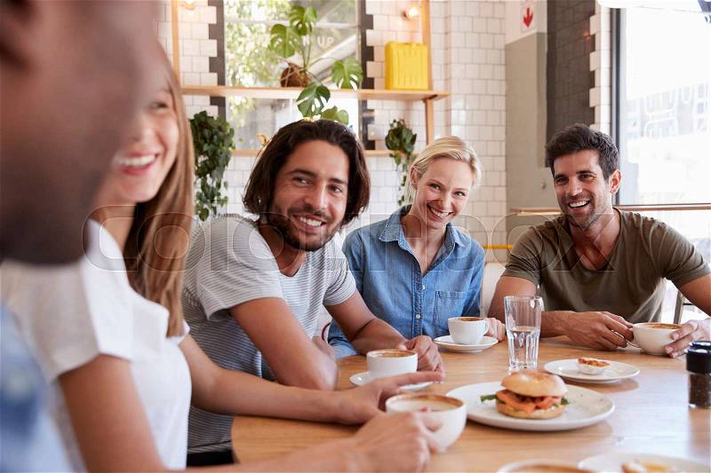 Group Of Friends Meeting For Lunch In Coffee Shop, stock photo