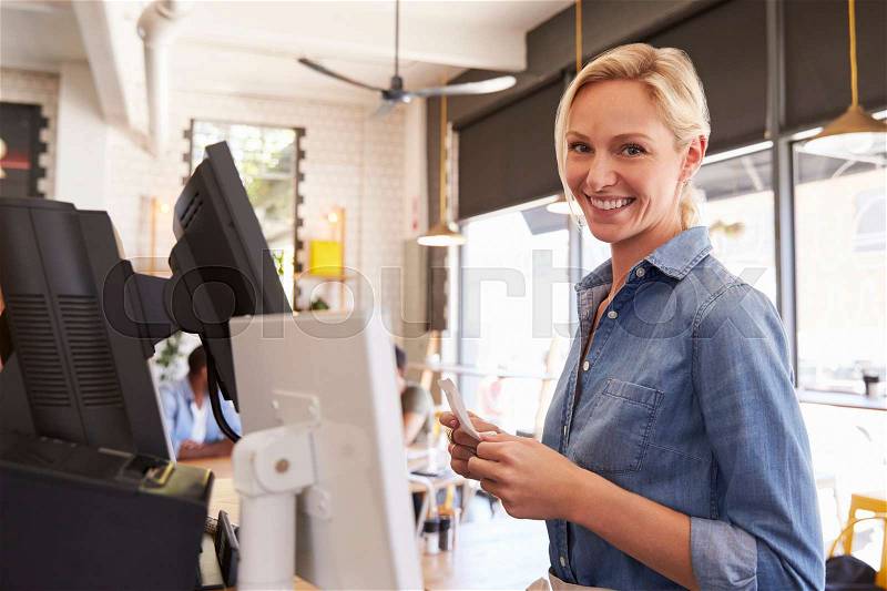 Portrait Of Waitress At Cash Register In Coffee Shop, stock photo