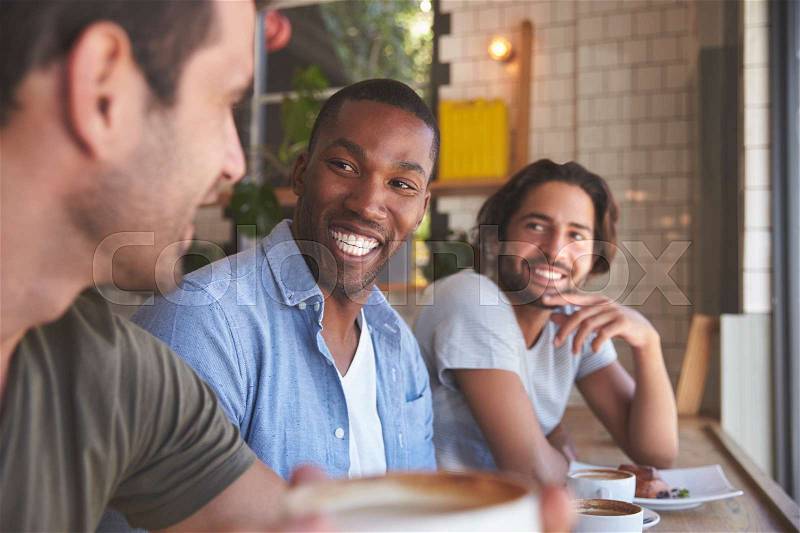 Three Male Friends Meeting In Coffee Shop, stock photo