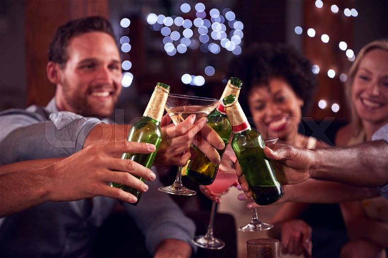 Young adult friends make a toast at a house party, close up, stock photo