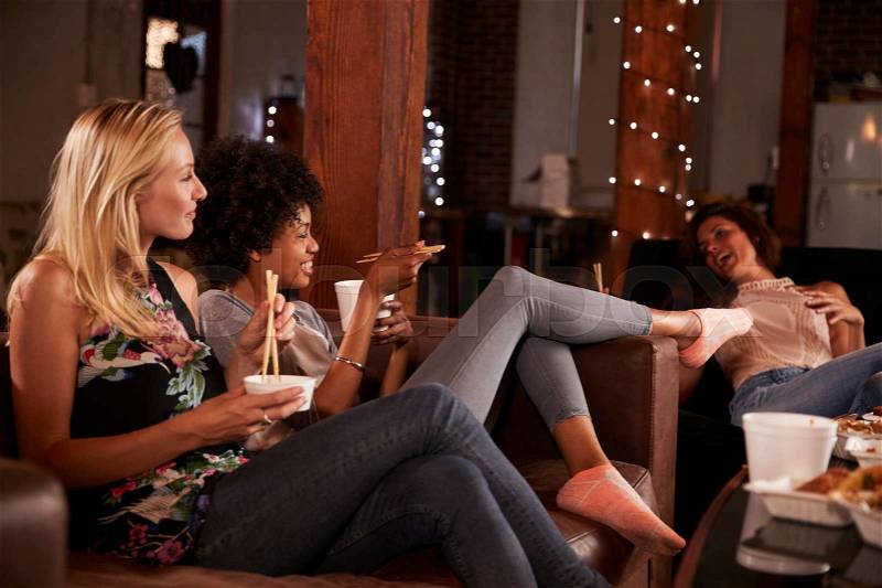 Three friends enjoy girl’s night in with a Chinese take-away, stock photo