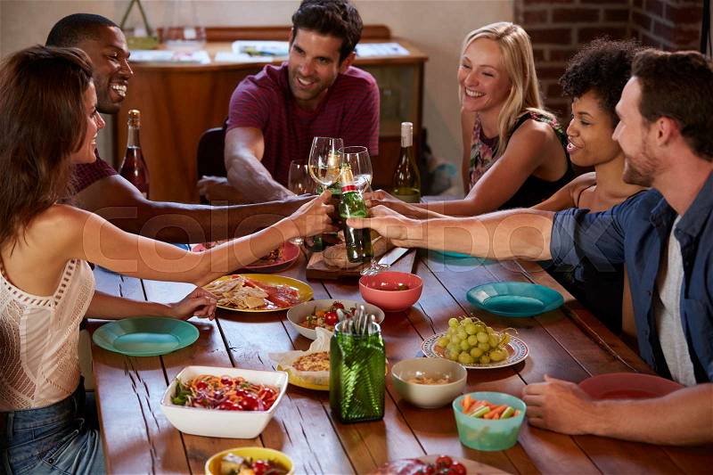 Six friends making a toast at a dinner party, elevated view, stock photo