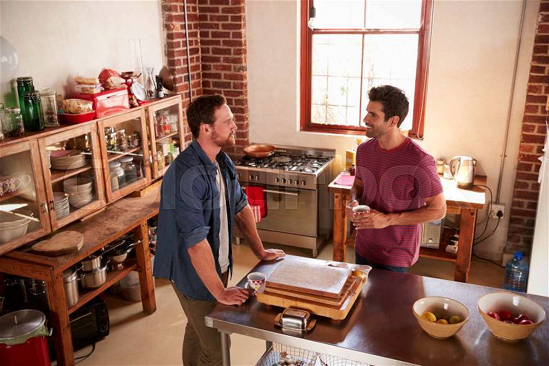 Two male friends hanging out in kitchen, high angle view, stock photo