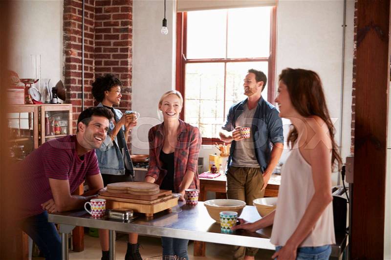 Five friends laughing over coffee in kitchen, close up, stock photo