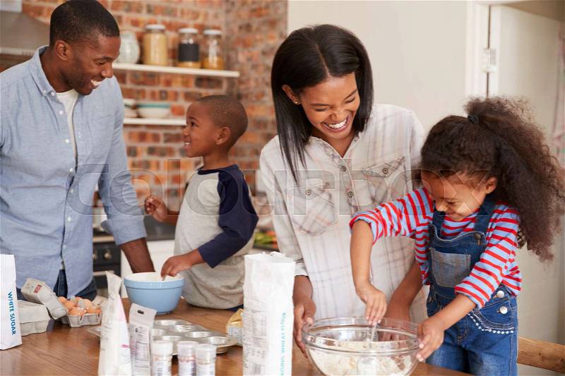 Parents And Children Baking Cakes In Kitchen Together, stock photo