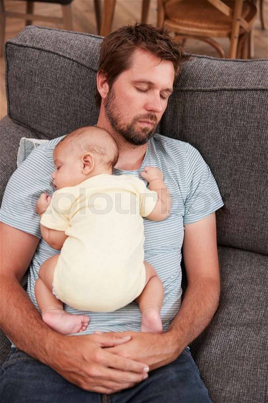 Tired Father With Baby Son Sleeping On Sofa Together, stock photo