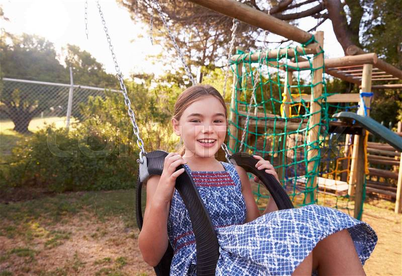 Girl Playing Outdoors At Home On Garden Swing, stock photo