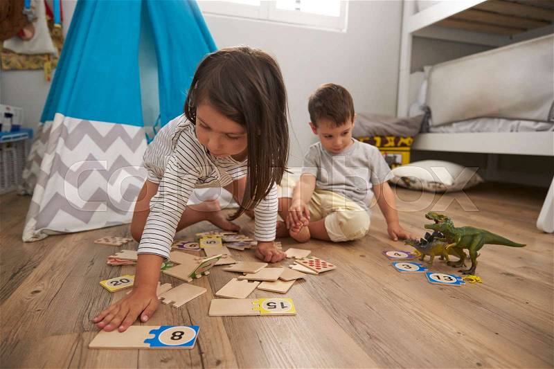 Two Children Playing Number Puzzle Game Together In Playroom, stock photo