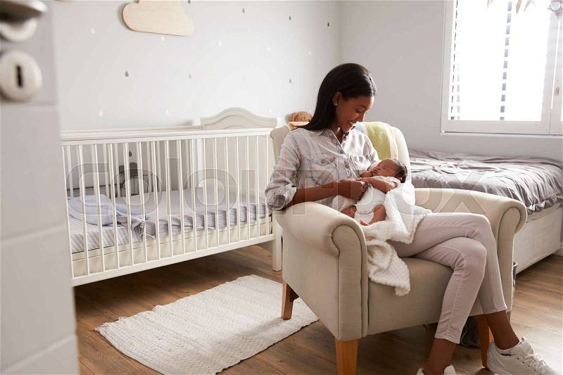 Mother Home from Hospital With Newborn Baby In Nursery, stock photo