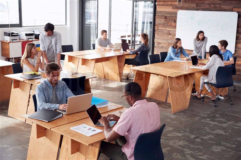 Young adult colleagues working in busy office, elevated view, stock photo