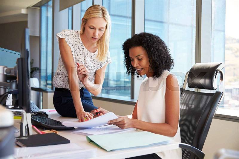 Businesswomen Working At Office Desk On Computer Together, stock photo
