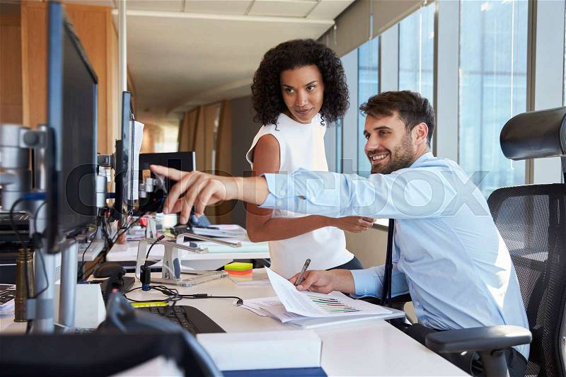 Businesspeople Working At Office Desk On Computer Together, stock photo