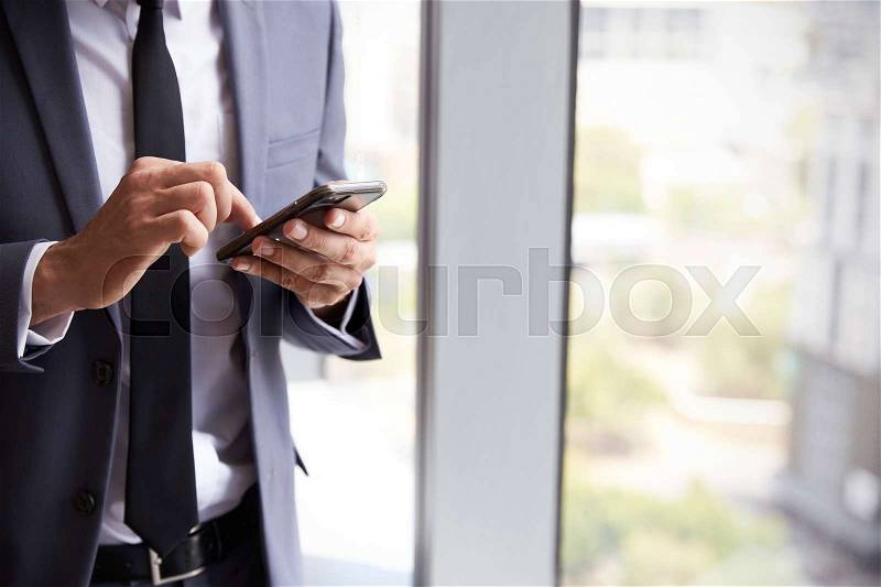 Close Up Of Businessman Checking Messages On Mobile Phone, stock photo