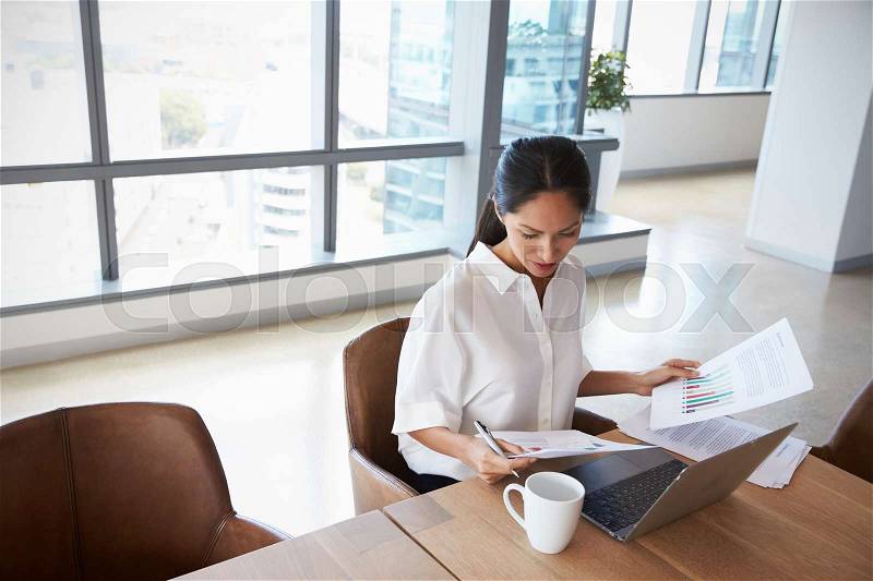 Businesswoman Working Alone On Laptop In Office Boardroom, stock photo