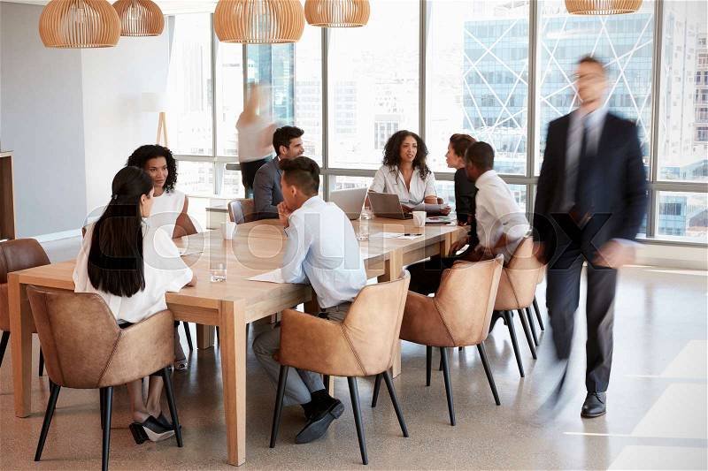 Group Of Businesspeople Sitting Around Table In Meeting Room, stock photo