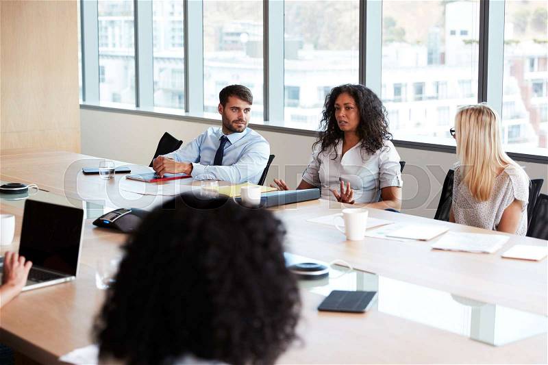 Businesswoman Leads Meeting Around Board Table, stock photo
