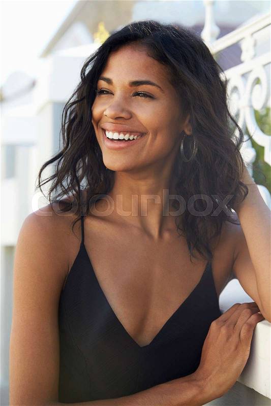 Young Latin American woman outdoors looking away smiling, stock photo
