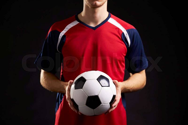 Close Up Of Professional Soccer Player With Ball In Studio, stock photo