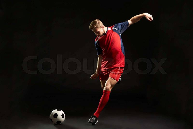 Professional Soccer Player Shooting At Goal In Studio, stock photo