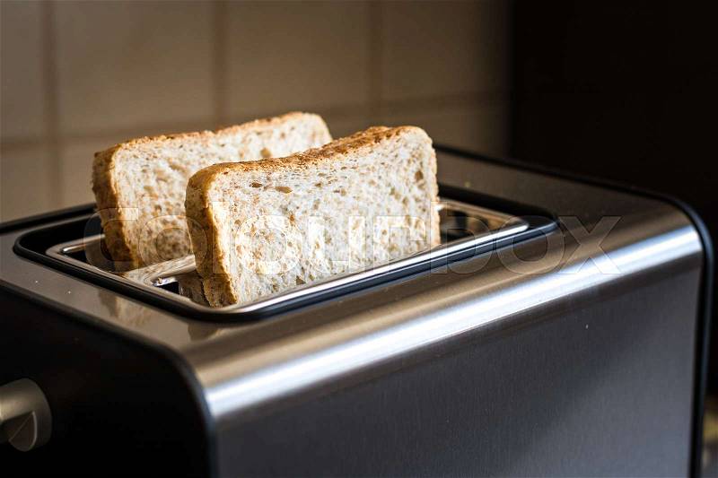 Toast is about to get toasted in toaster close up, stock photo