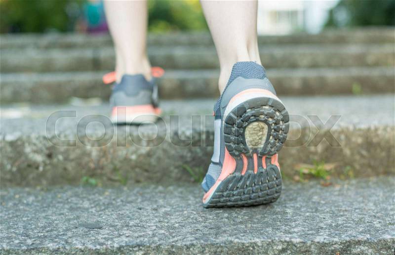 Running up the stairs with running shoes close up from behind, stock photo