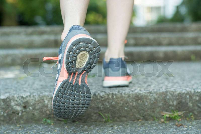 Running up the stairs with running shoes close up from behind, stock photo
