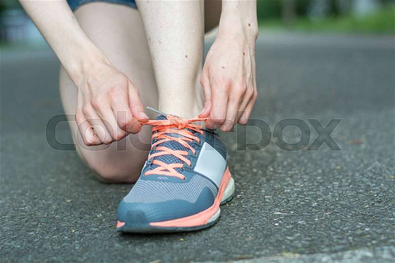 Do up the shoelaces on the tarmac close up, stock photo