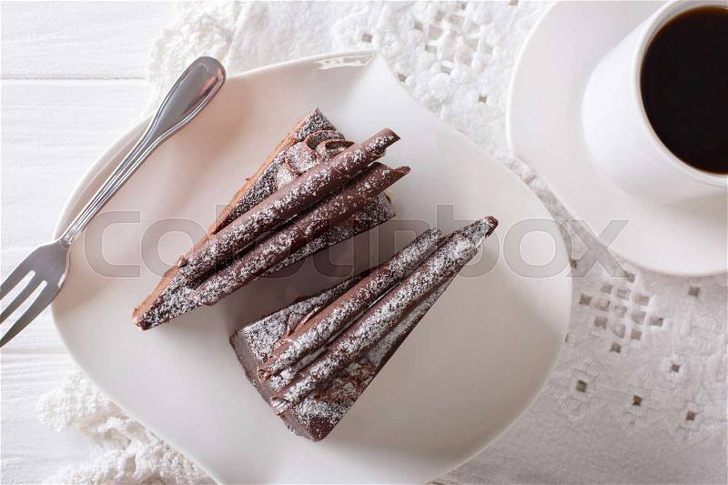 Pieces of chocolate truffle cake on a plate and coffee close-up on a table. horizontal view from above , stock photo