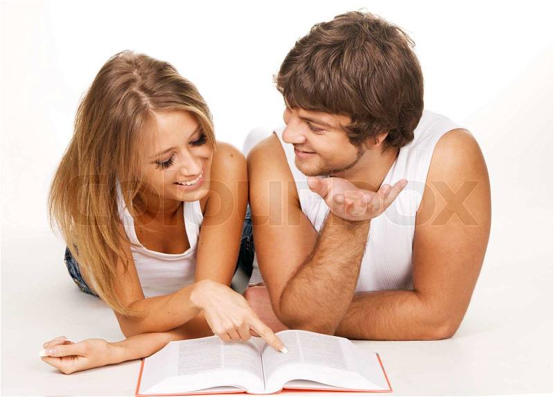 Young cheerful couple reading a book, white background, stock photo