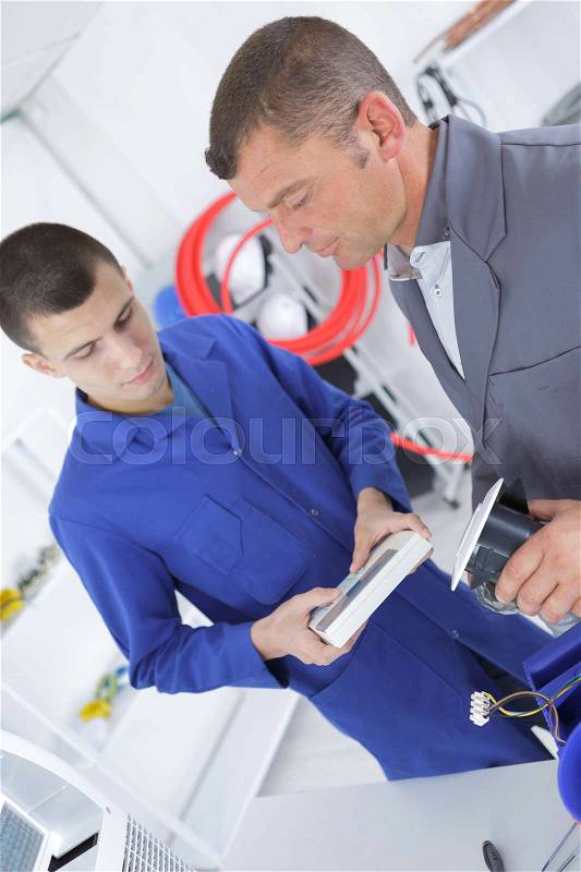 Teenager with professional brick layer in training school, stock photo