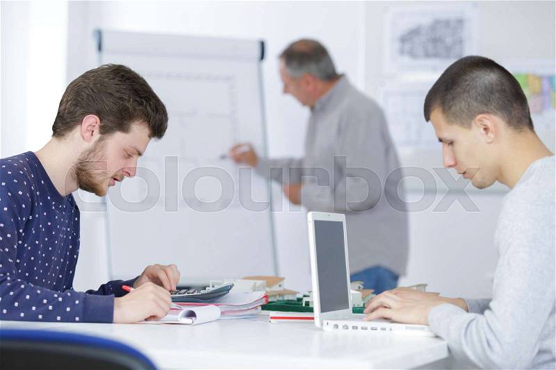 Male teacher and students at adult education class, stock photo