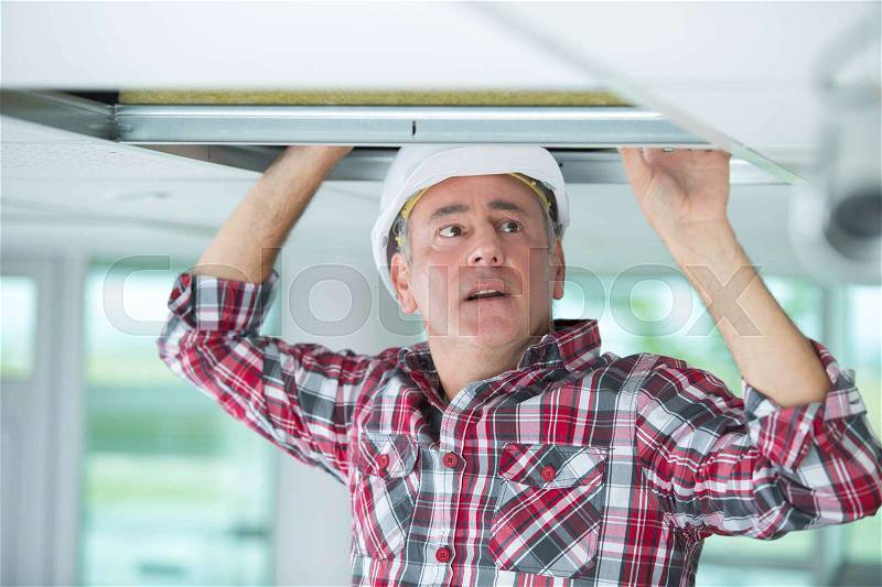 Man doing an installation of air conditioner and heating duct, stock photo