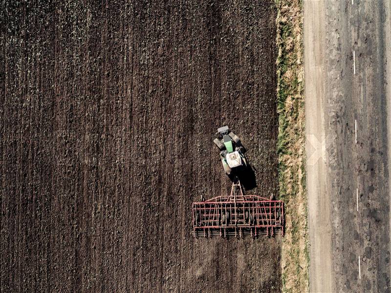 Tractor plowing field, top view, aerial photo, stock photo