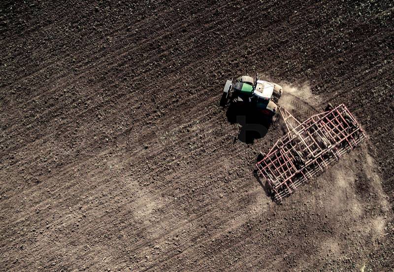Tractor plowing field, top view, aerial photo, stock photo