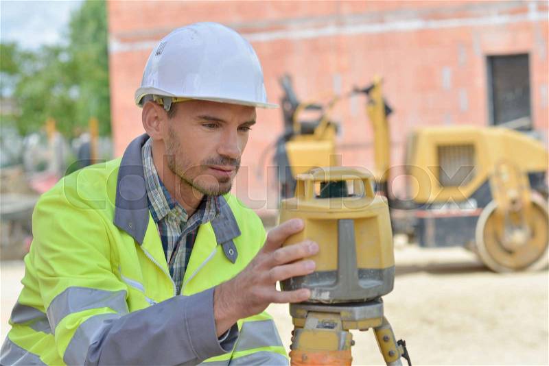 Surveyor on building site, stock photo