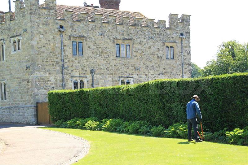 The gardener is cutting the grass in the neighourhood of Leeds Castle in England in the summer, stock photo