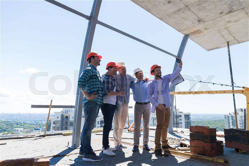 Team Of Builders Happy Smiling Take Selfie Photo During Meeting With Architect And Engineer On Construction Site Over City View Background, stock photo