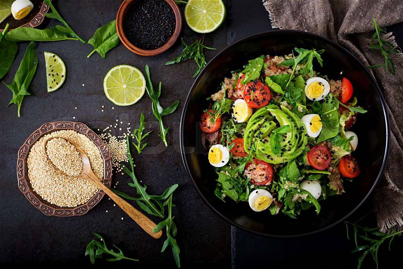 Diet menu. Healthy salad of fresh vegetables - tomatoes, avocado, arugula, egg, spinach and quinoa on a bowl. Flat lay. Top view, stock photo