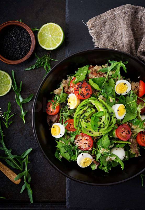 Diet menu. Healthy salad of fresh vegetables - tomatoes, avocado, arugula, egg, spinach and quinoa on a bowl. Flat lay. Top view, stock photo