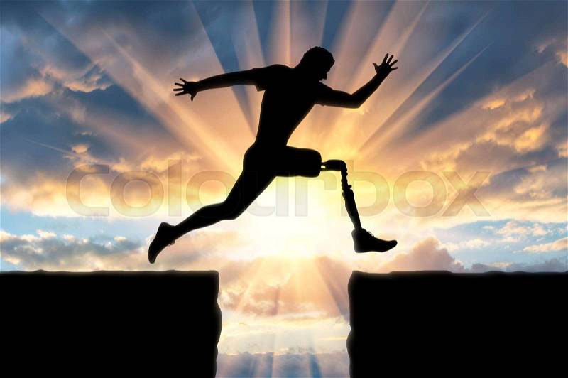 Concept of disability. Man with the prosthetic leg runs and jumps across the chasm, stock photo