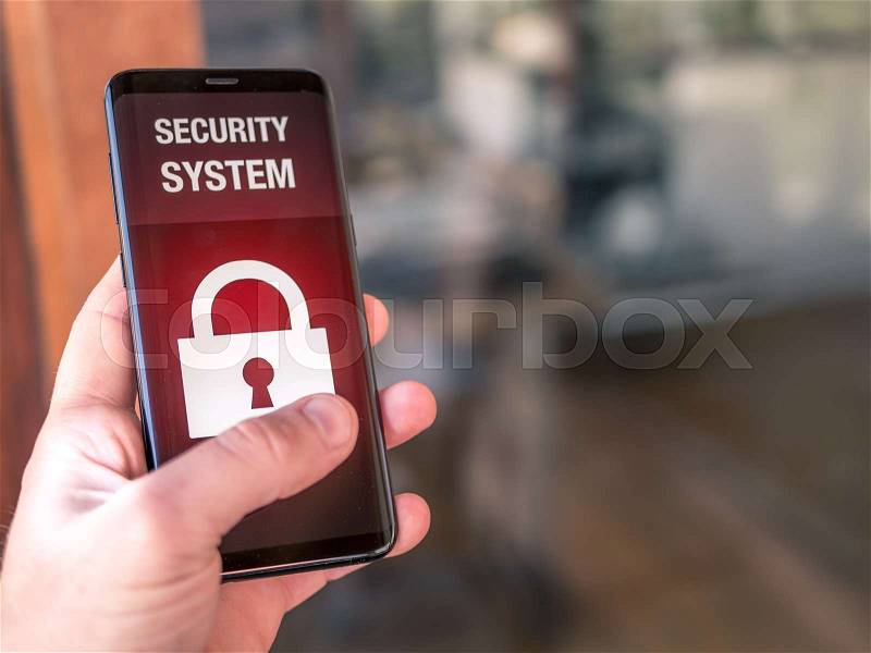 Mobile device in hand with security alarm app to unlock home, stock photo
