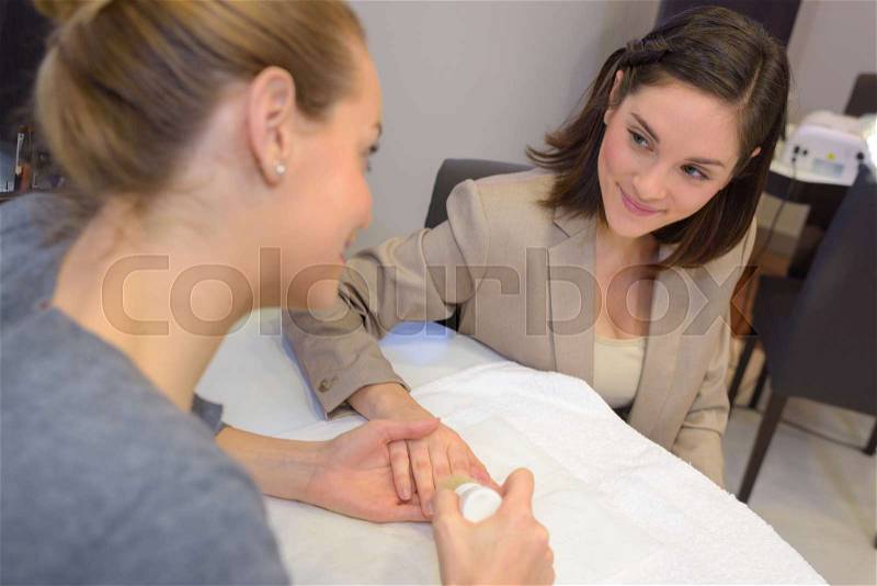 Lady having her nails done by beautician, stock photo