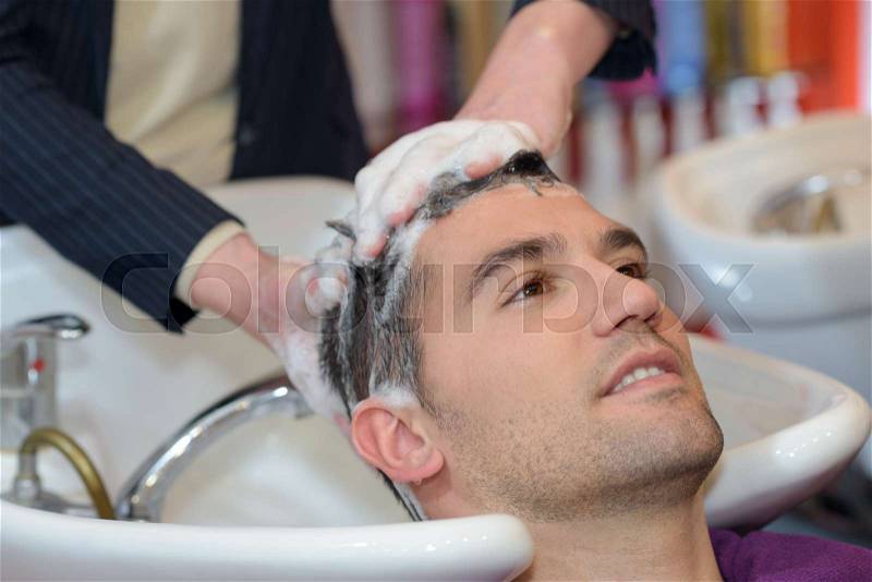 Man having hair washed in salon, stock photo