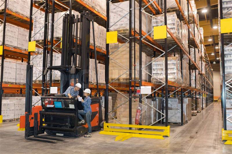 People talking by forklift truck in warehouse, stock photo