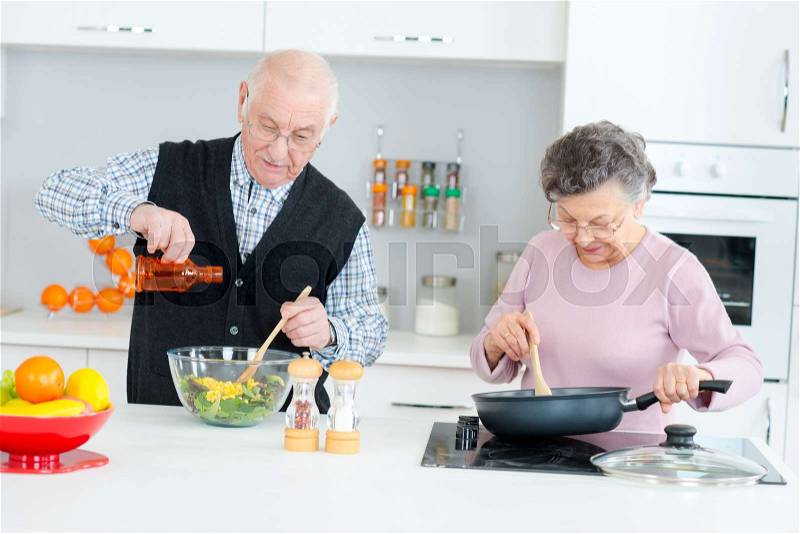 Elderly couple cooking, stock photo