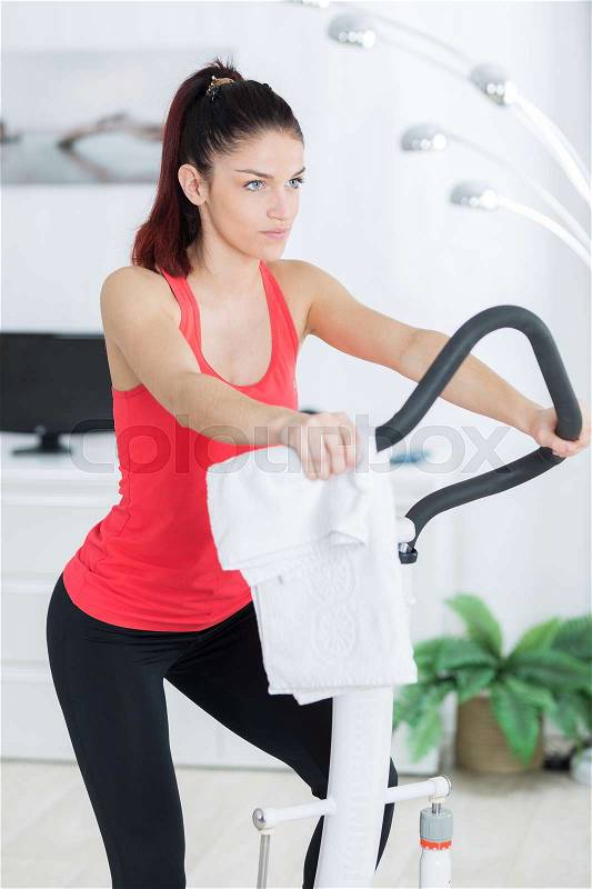Woman using indoor fitness equipment, stock photo